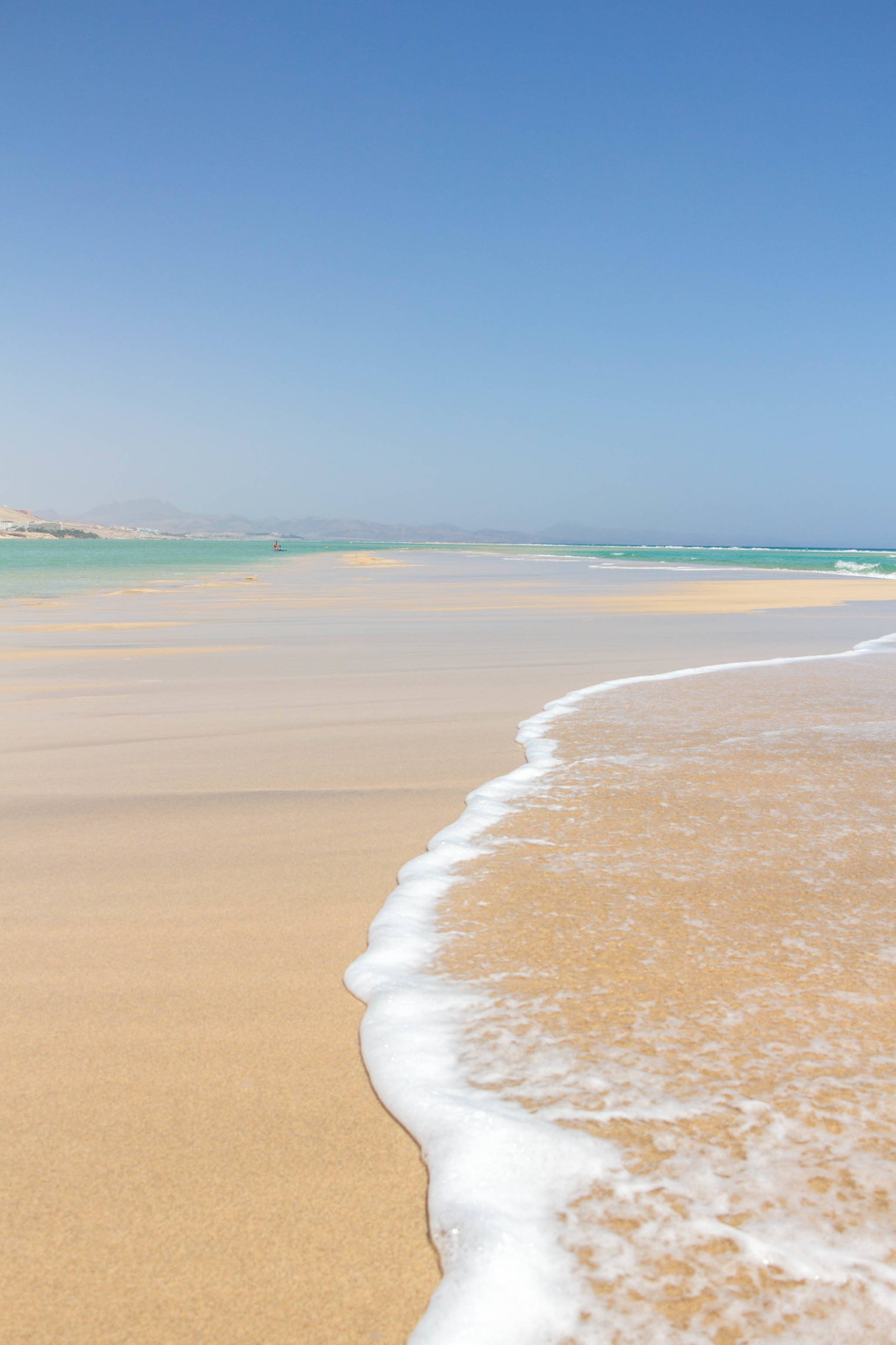 clear-blue-water-crawls-over-the-white-sandy-beach.jpg